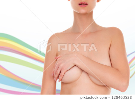 Woman with beautiful body examining her breasts for mastopathy or cancer against an abstract background with colorful lines and copyspace. Female healthcare concept Woman with beautiful body examining her breasts for mastopathy or cancer against an abstract background with colorful lines and copyspace. Female healthcare concept 128463528