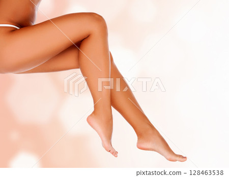 Long smooth female legs against an abstract background with circles and copyspace Long smooth female legs against an abstract background with circles and copyspace 128463538
