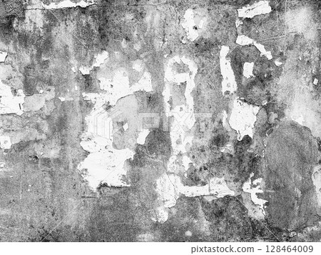 A very old and decaying building wall has peeling white paint and black stains. 128464009