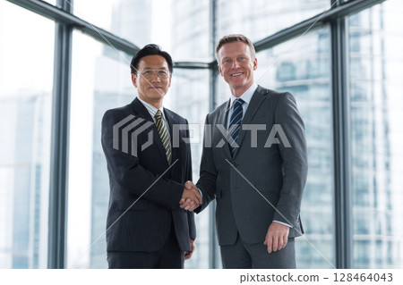 Handshake between business professionals partnership, agreement, trust, collaboration, commitment, and corporate success in strategic business context 128464043