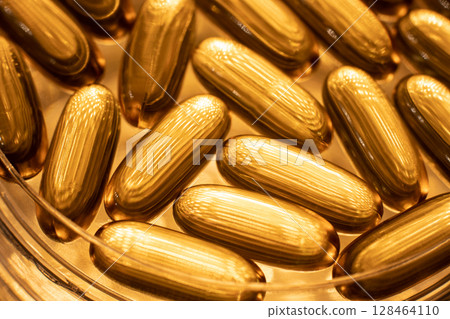 Close-up of shiny yellow vitamin capsules, healthy concept 128464110