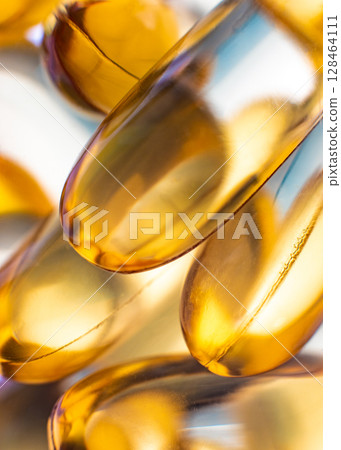 Close-up of shiny yellow vitamin capsules, healthy concept 128464111