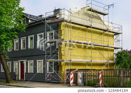 Insulation of wooden residential building exterior walls with thick thermal insulation boards Insulation of wooden residential building exterior walls with thick thermal insulation boards 128464184