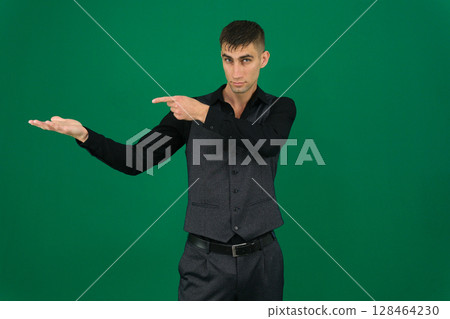 Photo of young man happy positive smile look indicate thumb empty space recommend advert isolated over grey color background Photo of young man happy positive smile look indicate thumb empty space recommend advert isolated over grey color background 128464230