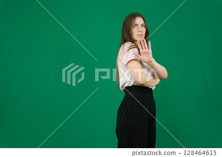 Stop. Concerned Asian woman showing refusal sign, saying no, raise awareness, standing over blue background 128464615