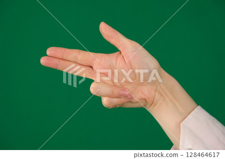 A high-quality image of a human hand making a finger gun gesture against a solid blue background. symbolize shooting, targeting, or action related themes 128464617