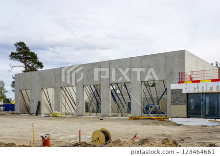 Modern Concrete Structure Under Construction on a Commercial Site with Support Beams and Scaffolding Modern Concrete Structure Under Construction on a Commercial Site with Support Beams and Scaffolding 128464661
