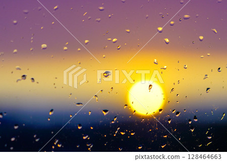 Sunset Through Raindrops on Glass - Blurred Horizon with Golden Light and Purple Sky 128464663