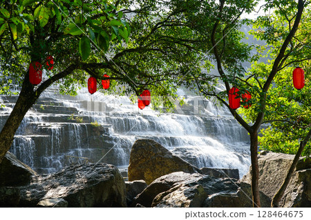Pongour Waterfall Framed by Trees with Red Lanterns in a Serene Natural Setting, Vietnam Pongour Waterfall Framed by Trees with Red Lanterns in a Serene Natural Setting, Vietnam 128464675
