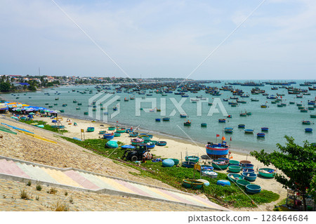 Dense Cluster of Traditional Boats Floating on the Tranquil Waters off Mui Ne Coastline in Vietnam Dense Cluster of Traditional Boats Floating on the Tranquil Waters off Mui Ne Coastline in Vietnam 128464684