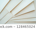 Sheets of paper layered and angled creating a textured abstract background 128465024