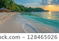 Serene beach at sunset with calm waters and tropical vegetation along the shore 128465026
