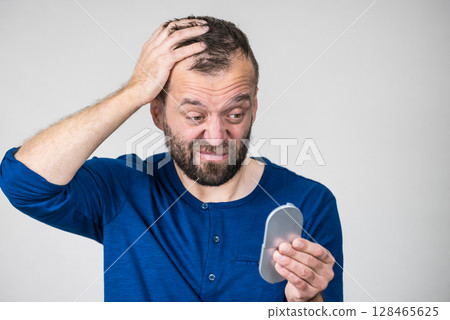 Worried man looking at little mirror 128465625