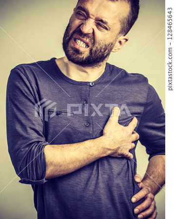 Man having stomach or ribs pain ache. 128465643