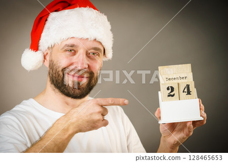 December 24th. Man santa hat holds calender 128465653