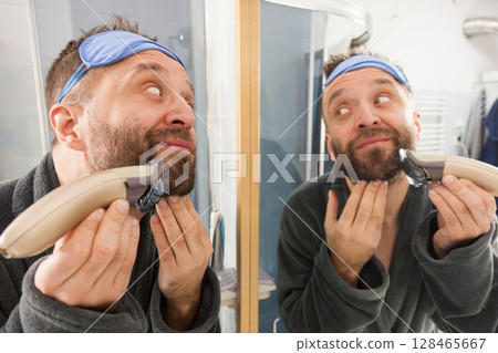 Man shaving trimming his beard 128465667