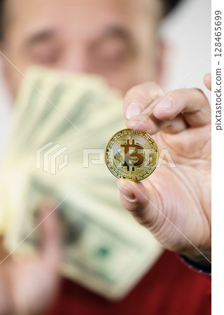 Man having bitcoin coin and cash 128465699