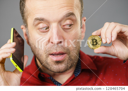 Man with bitcoin talking on phone Man with bitcoin talking on phone 128465704