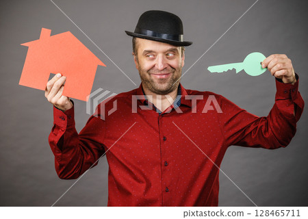 Man holding red house model and home keys Man holding red house model and home keys 128465711