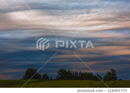 Photograph of a dramatic isolated Asperitas cumulus thunderstorm cloud 128465733