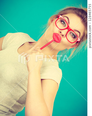Happy woman holding fake lips on stick Happy woman holding fake lips on stick 128465755