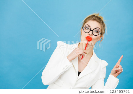 woman holds fake lips on stick pointing at copy space woman holds fake lips on stick pointing at copy space 128465761