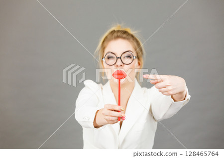 Happy elegant woman holding carnival accessoies on stick Happy elegant woman holding carnival accessoies on stick 128465764