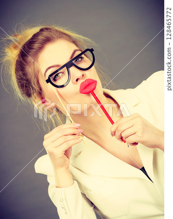 Happy elegant woman holding carnival accessoies on stick Happy elegant woman holding carnival accessoies on stick 128465772