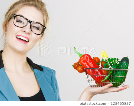 Woman holds shopping basket with vegetables 128465827