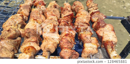 Street food, meat grilled over a fire. Grilled meat skewers on barbecue outdoors. Street food, meat grilled over a fire. Grilled meat skewers on barbecue outdoors. 128465881