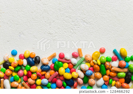 Mixed collection of colorful candy, on colored background. Flat lay, top view. frame of colorful chocolate coated candy 128466292