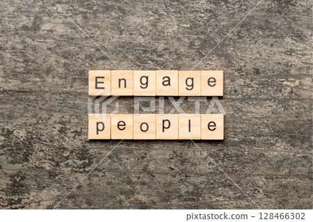 ENGAGE PEOPLE word written on wood block. ENGAGE PEOPLE text on cement table for your desing, concept 128466302