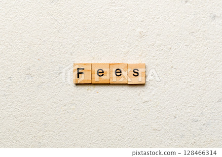 Fees word written on wood block. Fees text on cement table for your desing, Top view concept 128466314