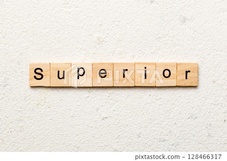 SUPERIOR word written on wood block. SUPERIOR text on cement table for your desing, concept 128466317