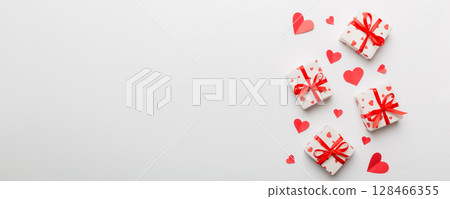 Valentine day composition: red gift box with bow and heart. Christmas present. View from above. Space for text. Holday greeting card 128466355