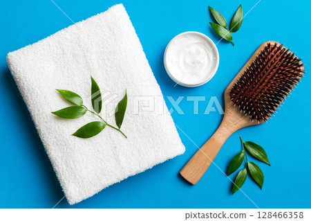 cosmetic for hair care, cream and towel on a colored background top view. flat lay cosmetic for hair care, cream and towel on a colored background top view. flat lay 128466358