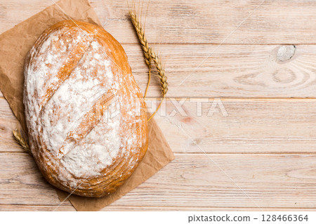 Freshly baked delicious french bread with napkin on rustic table top view. Healthy white bread loaf 128466364