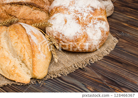 Homemade natural breads. Different kinds of fresh bread as background, perspective view with copy space 128466367