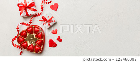 Delicious chocolate pralines in box for Valentine's Day. Heart shaped with gift box of chocolates top view with copy space Delicious chocolate pralines in box for Valentine's Day. Heart shaped with gift box of chocolates top view with copy space 128466392