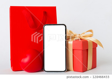 mobile phone with blank screen on colored background with hearts, calendar and gift box, valentine day concept perspertive view flat lay mobile phone with blank screen on colored background with hearts, calendar and gift box, valentine day concept perspertive view flat lay 128466433