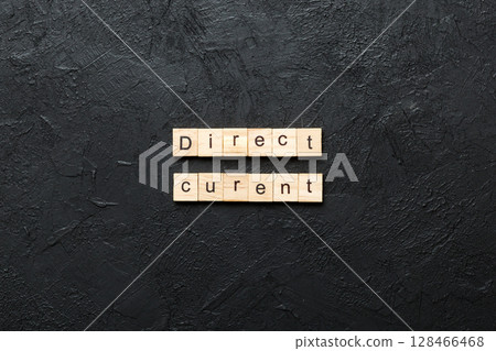 direct current word written on wood block. direct current text on cement table for your desing, concept 128466468
