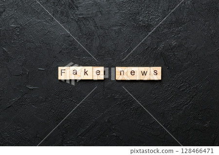 fake news word written on wood block. fake news text on table, concept 128466471