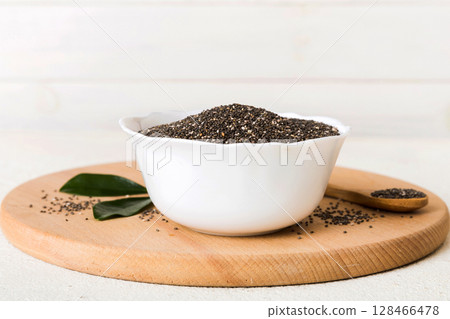 Chia seeds in bowl and spoon on colored background. Healthy Salvia hispanica in small bowl. Healthy superfood 128466478