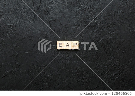 EAP word written on wood block. employee assistance program text on table, concept 128466505