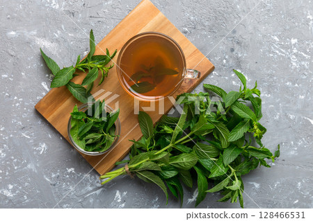 Cup of mint tea on table background. Green tea with fresh mint top view with copy space 128466531