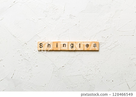 Shingles word written on wood block. Shingles text on cement table for your desing, concept 128466549