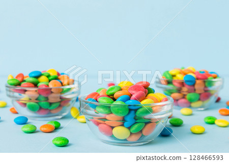 Multicolored candies in a bowl on a colored background. birthday and holiday concept. Top view with copy space Multicolored candies in a bowl on a colored background. birthday and holiday concept. Top view with copy space 128466593