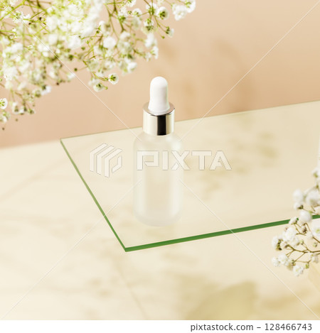 Moisturizing serum. Glass dropper bottle with natural serum on glass shelf on light biege background with white flowers. Organic beauty product and skin friendly cosmetics concept. Mockup 128466743