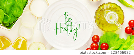 Organic farm vegetables and empty white plate with text Be Healthy on white background. The concept of vegan healthy food and detox. Ingredients for vegetables salad. Banner size Organic farm vegetables and empty white plate with text Be Healthy on white background. The concept of vegan healthy food and detox. Ingredients for vegetables salad. Banner size 128466922