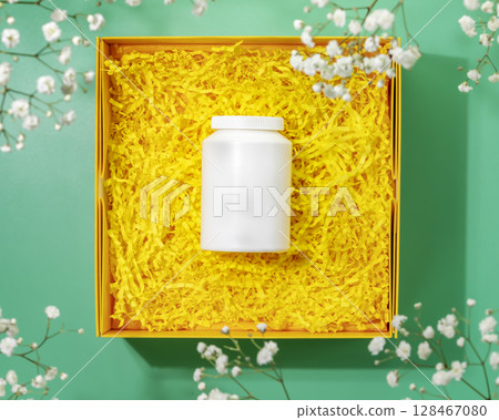 Gift for health. Yellow gift box with vitamins or supplements. Preparing health package, craft gift box with white pharmacy bottle. Mockup of supplements. Womans day, mothers day holidays. Flat lay Gift for health. Yellow gift box with vitamins or supplements. Preparing health package, craft gift box with white pharmacy bottle. Mockup of supplements. Womans day, mothers day holidays. Flat lay 128467080
